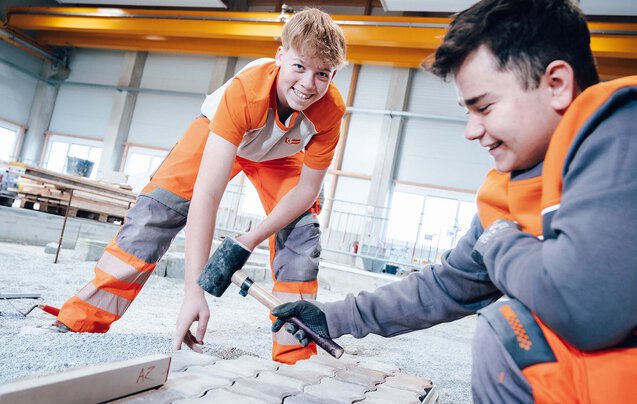 Zwei Leyrer + Graf Lehrlinge beim Pflastern im Ausbildungszentrum