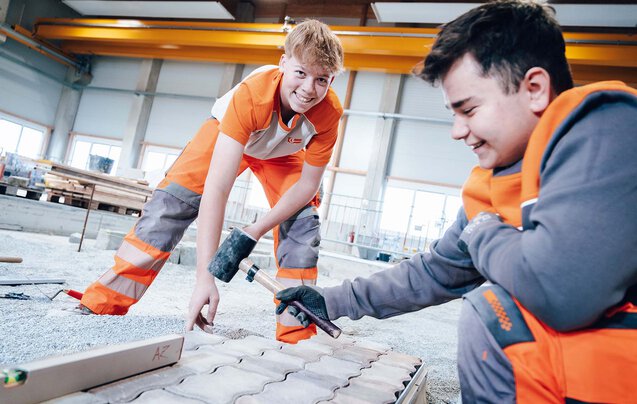 Zwei Leyrer + Graf Lehrlinge beim Pflastern im Ausbildungszentrum