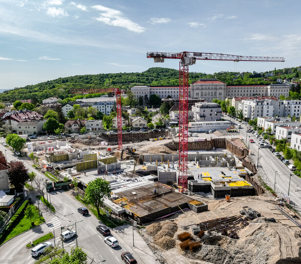 Leyrer + Graf Bauvorhaben Wohnhausanlage Grutschgasse, Mödling in der Bauphase mit rotem Kran und grüner und städtischer Umgebung Umgebung 
