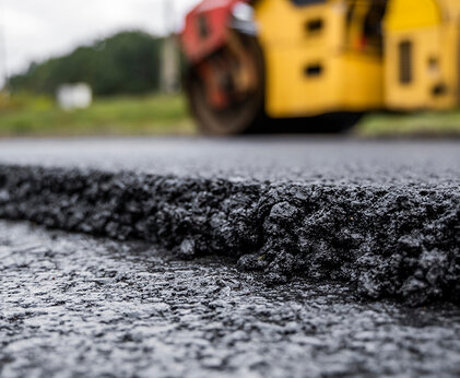 Nahaufnahme von Asphalt der gerade auf der Straße aufgetragen wird