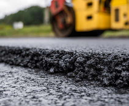 Nahaufnahme von Asphalt der gerade auf der Straße aufgetragen wird