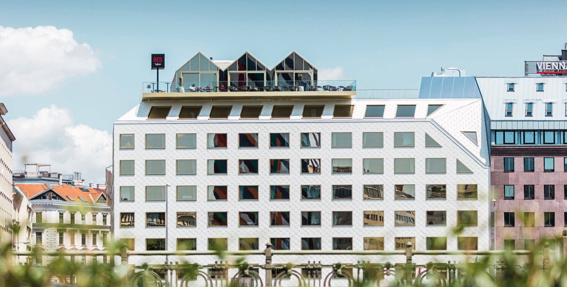 Fertiggestelltes Hochbau-Projekt von Leyrer + Graf - mehrstöckiges luxuriöses Gebäude mit weißer Fassade und Dachterasse - Radisson Red Wien 