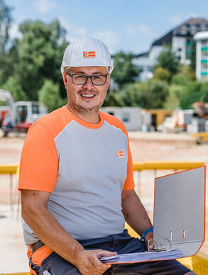 Portraitaufnahme eines Leyrer + Graf Mitarbeiters der direkt in die Kamera lächelt