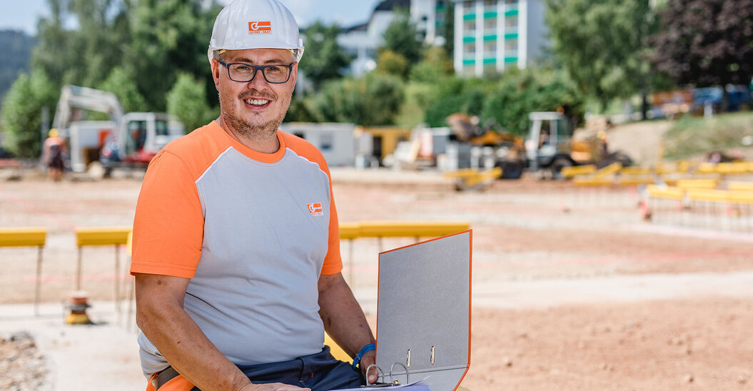 Portraitaufnahme eines Leyrer + Graf Mitarbeiters der direkt in die Kamera lächelt