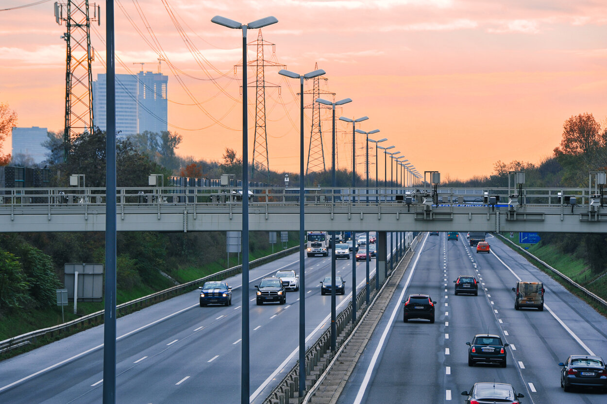 Stadteinfahrt im Sonnenuntergang im Fokus steht die Straßenbeleuchtung