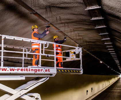 Zwei Leyrer + Graf Mitarbeiter bei Montagearbeiten in einer Tunnelanlage