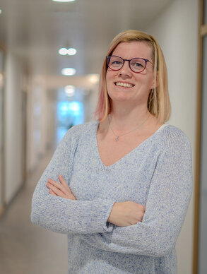 Leyrer + Graf Mitarbeiterin mit verschränkten Armen und blickt stolz in die Kamera